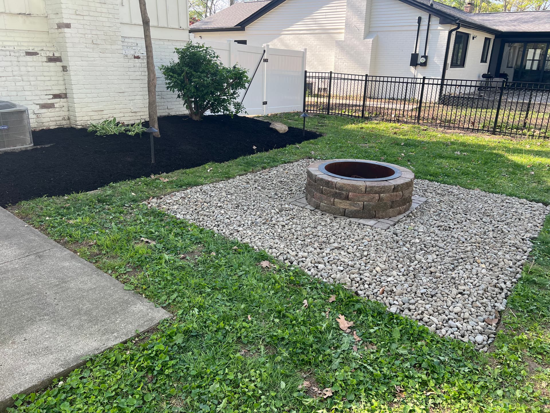 Fire pit area cleanup with river rock and mulch in northwest Indianapolis image